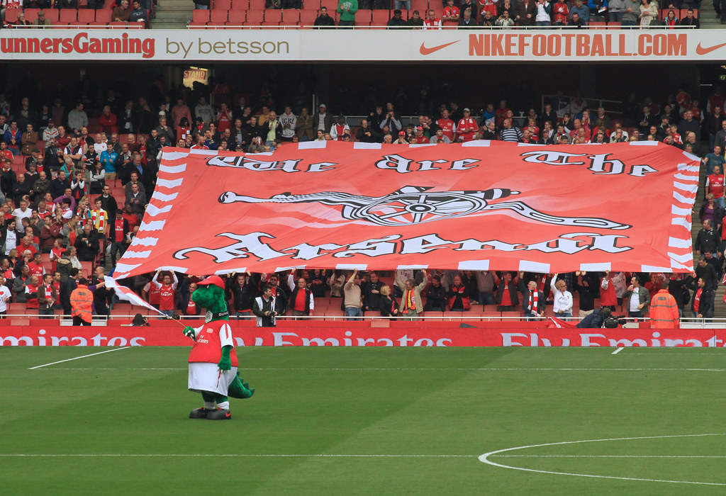Fans d’Arsenal brandissant le drapeau de leur équipe lors d’un match